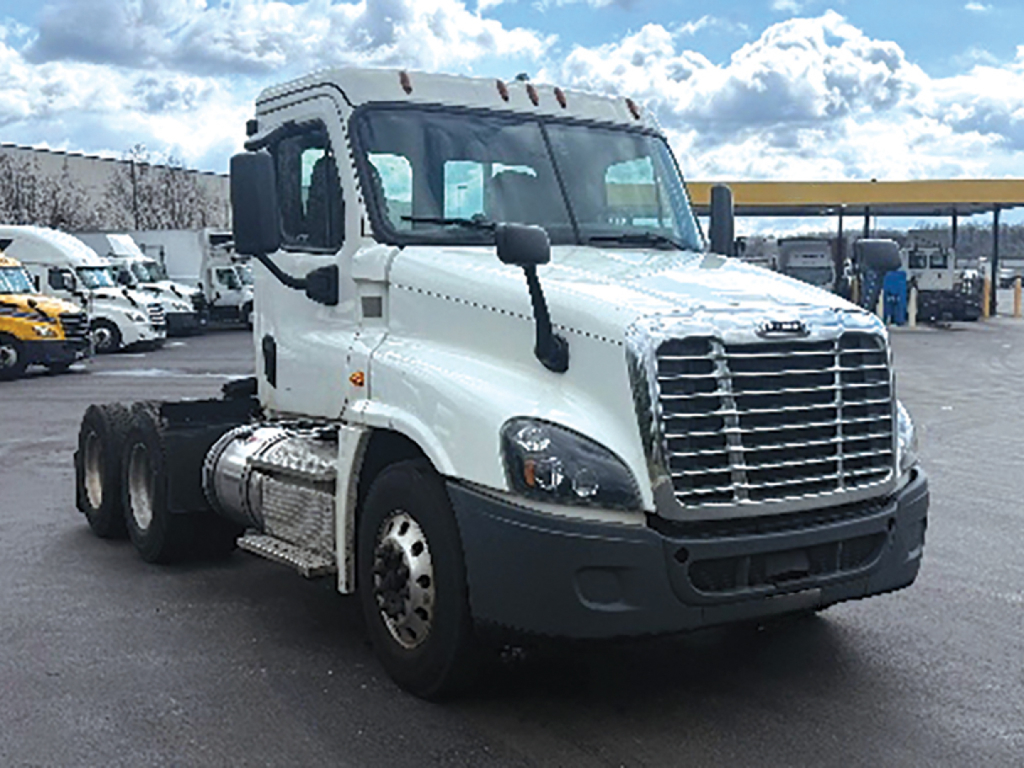 Truck cab showing Freightliner Freightliner Cascadia125 chassis with white exterior and dual rear axles, front grille and side mirrors visible.