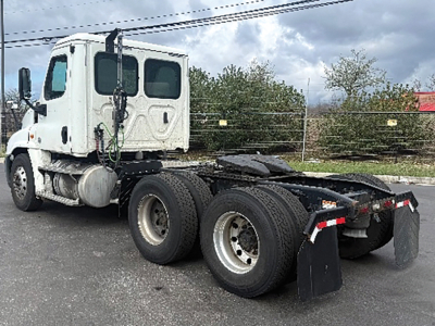 Freightliner Cascadia125 tractor chassis showing rear view with dual rear axles and mud flaps.