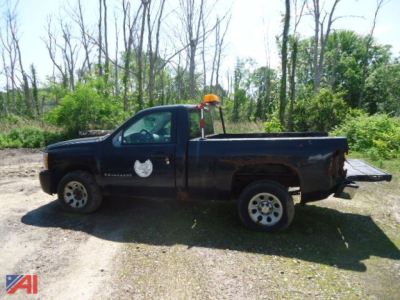 2007 Chevrolet Silverado pickup truck 2wd in a dark color with utility light on cab, side emblem visible, pickup bed in yard.