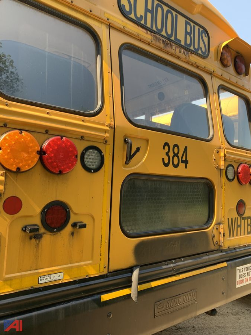 Back of a yellow 2017 Blue Bird Vision school bus showing rear with lights, number 384, window, and dealership stickers.