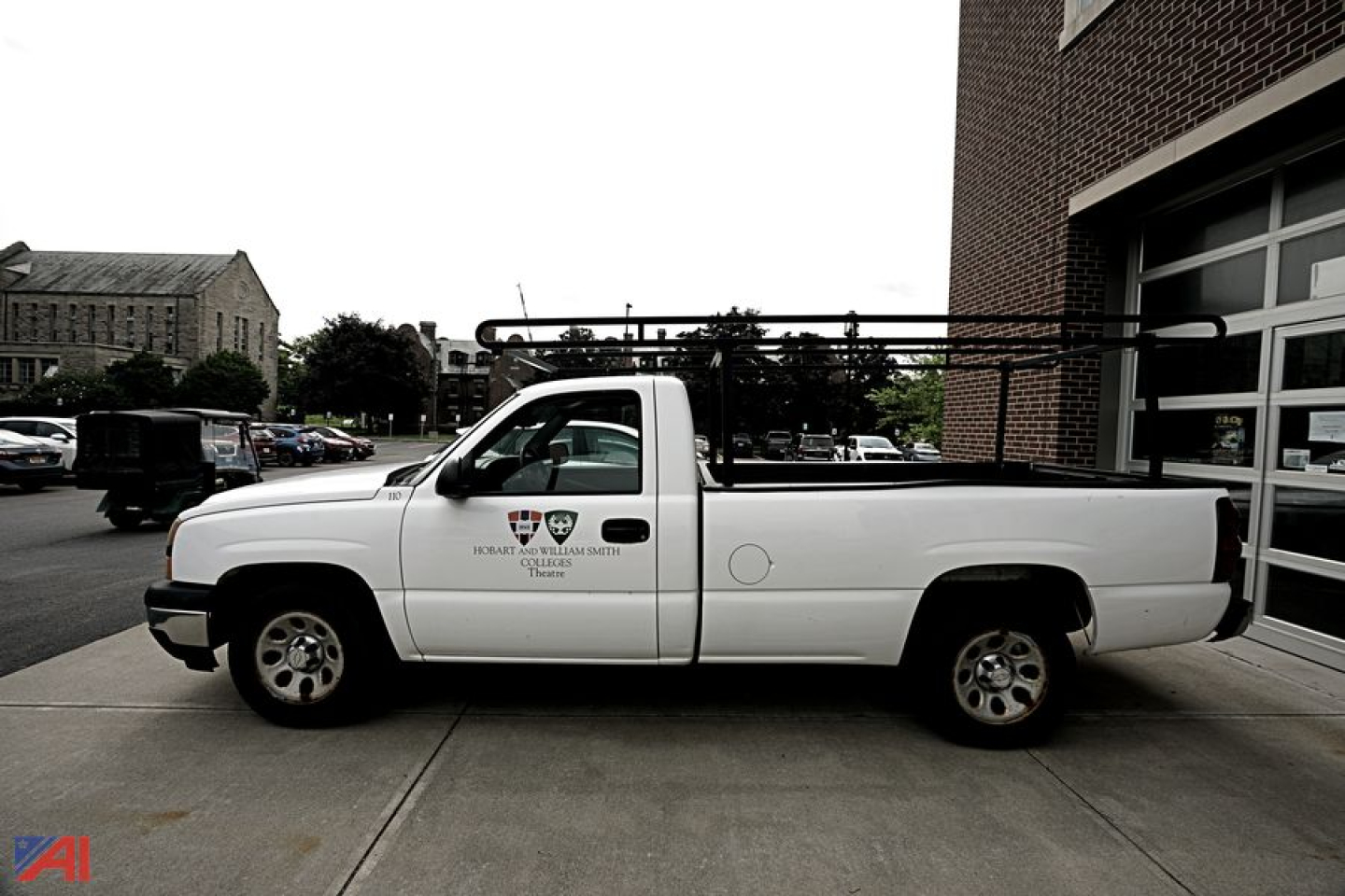 Chevrolet Silverado 1500 pickup truck side view showing ladder rack and crew cab, white color, with badges on front door.