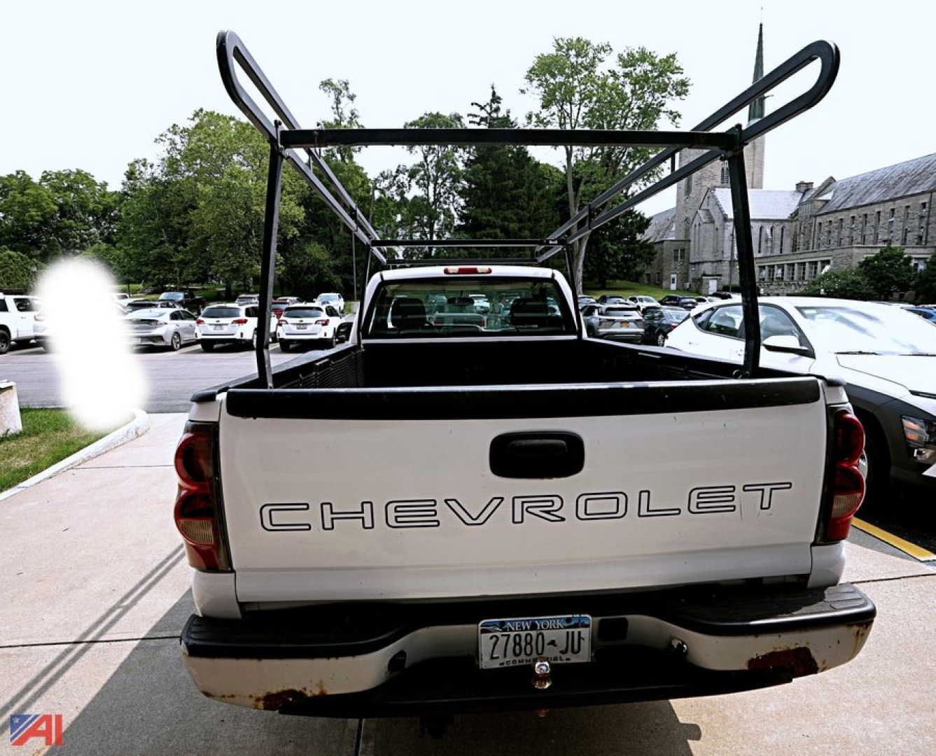 Chevrolet Silverado 1500 pickup truck tailgate view with a metal rack over the bed, rear bumper, and license plate visible