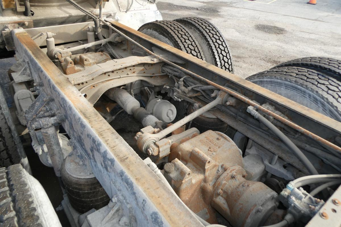 Truck chassis view showing engine bay area and drivetrain along left side with exposed components and hoses.