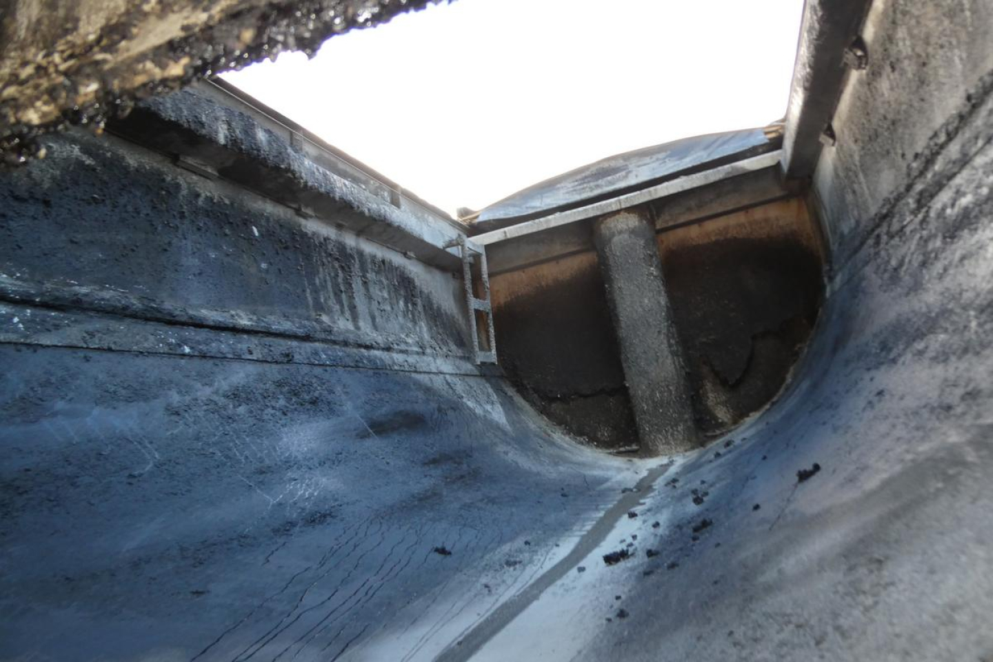 Dump truck bed interior showing metal walls and a reinforced chute from a Mack CV Granite CV713 dump truck.