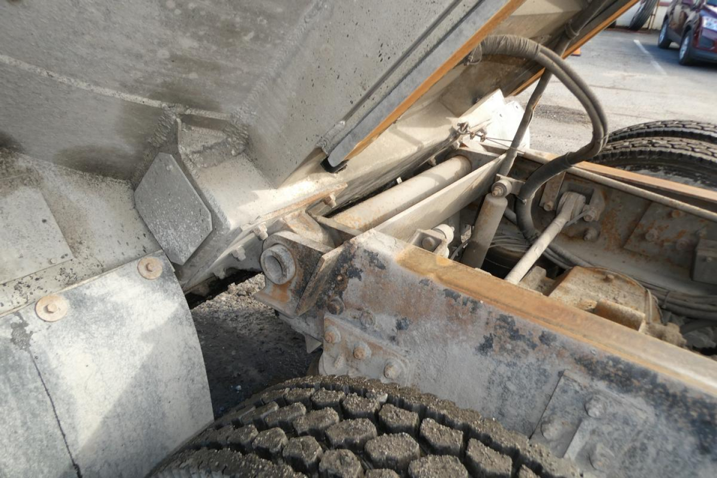 Truck chassis and suspension area showing tie rod, hydraulic hoses, and wheel hub from a Mack CV Granite CV713.
