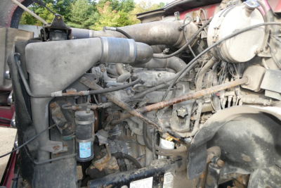 Engine compartment of a 2005 Mack CV Granite CV713 showing hoses, belts, and various components.