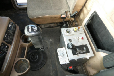 Mack CV Granite CV713 interior showing gear shifter and control panel with switches and gauges.