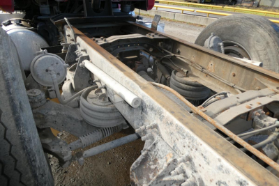 Chassis and suspension components of a Mack CV Granite 2005 truck showing frame rails, leaf springs, air springs, and suspension hardware.