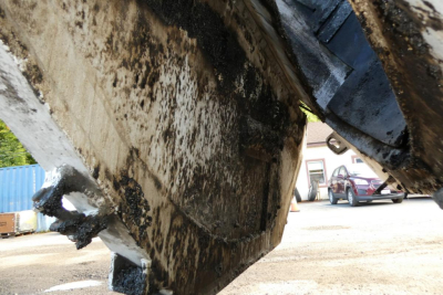Dump truck undercarriage showing dirt and grime on the frame and body panels.