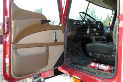 Truck cab interior and door panel of a red 2005 Mack CV Granite CV713 showing steering wheel and dashboard.