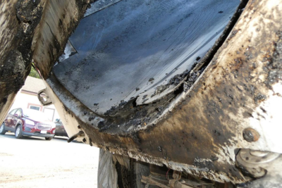 Truck dump bed underside with mud and wear visible showing damaged seal and dirt.