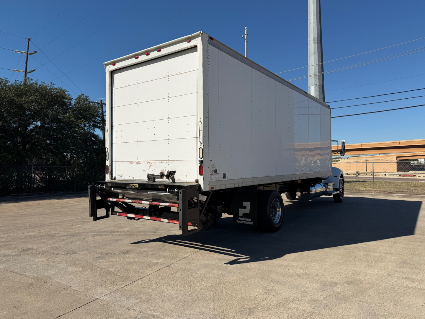 Peterbilt 337 box truck rear view showing cargo box with rear doors and black hitch bumper.