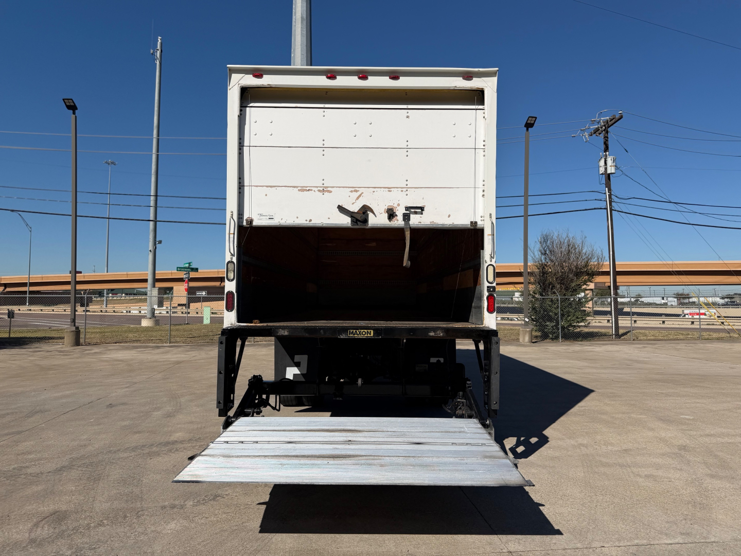 Peterbilt 337 box truck rear view with ramp down, rear loading area visible, VIN plate area not legible, used vehicle in lot.