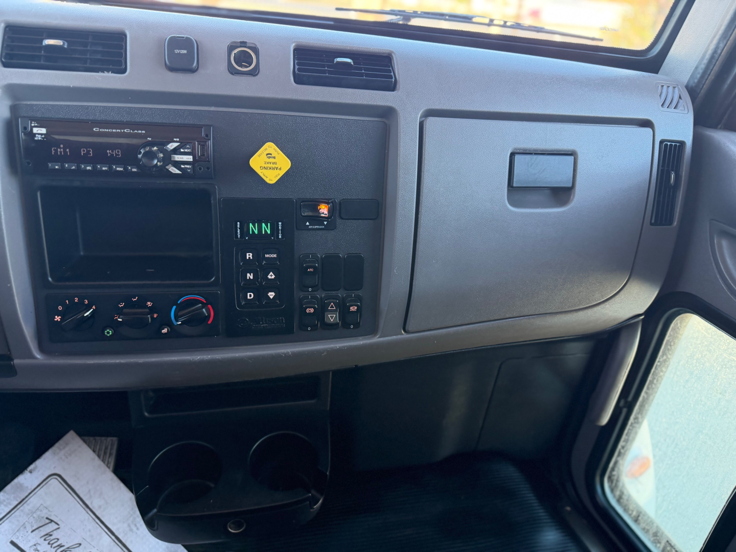 Peterbilt 337 driver dashboard panel showing climate controls and gear selector in view.