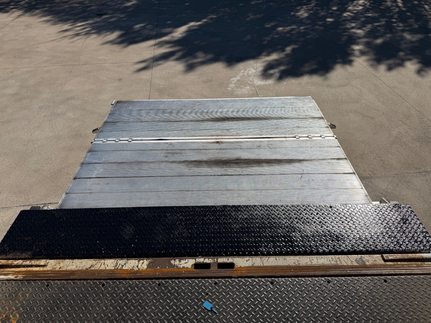 2020 Peterbilt 337 flatbed/box truck tail area showing aluminum ramp and diamond plate surface, rear view