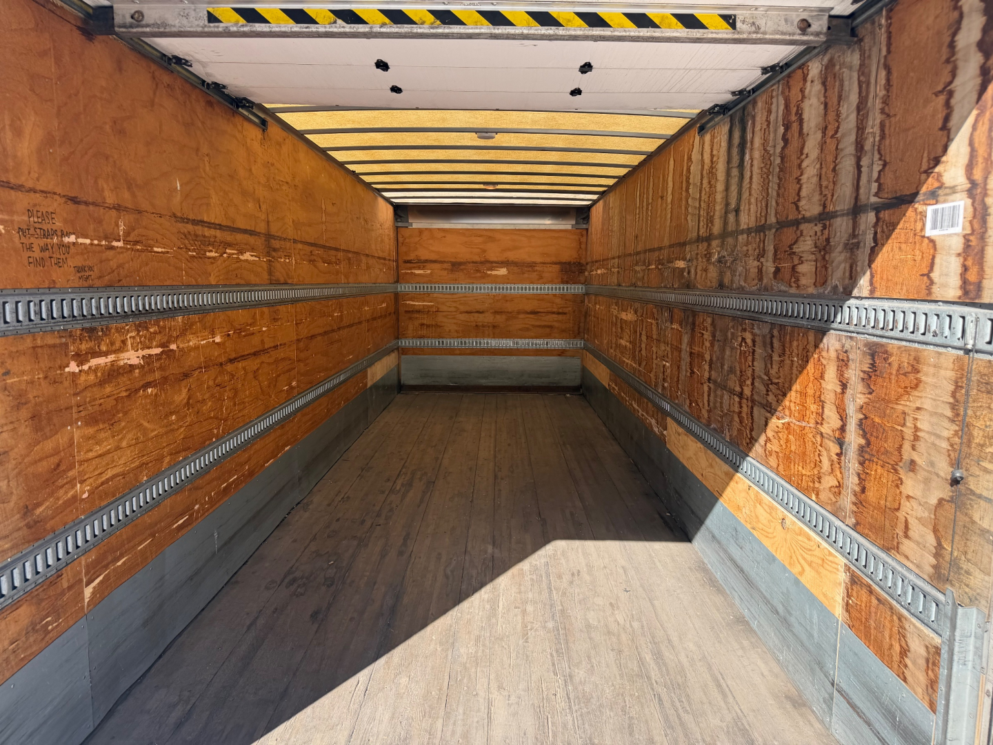Empty Peterbilt 337 truck trailer interior with wooden walls and metal E-track rails.