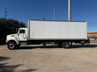 Peterbilt 337 box truck side view showing white cargo box and cab with dual rear wheels, daytime clear sky.