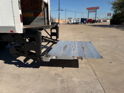 Peterbilt 337 box truck tail with lowered aluminum lift gate showing metal platform and support arms.