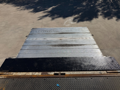 2020 Peterbilt 337 flatbed/box truck tail area showing aluminum ramp and diamond plate surface, rear view