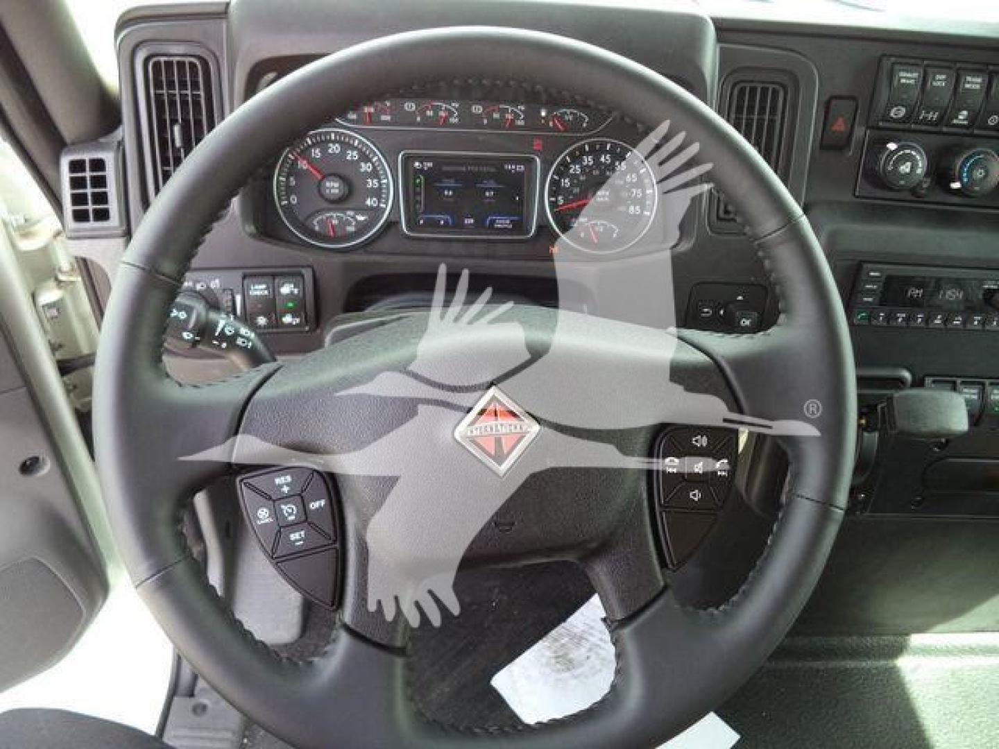 Dashboard and steering wheel of a 2027 International MV truck showing instrument cluster, steering wheel with International logo, and control panels.