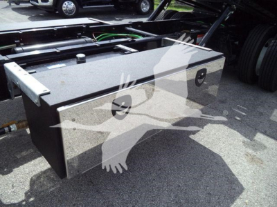 Truck chassis showing a rectangular metal fuel or storage tank mounted beside the cab with a cap on top, part of International MV rollback truck.