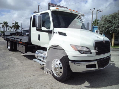 White International MV truck in a rollback configuration with flatbed, showing cab and bumper; no legible model text on the image beyond truck components.