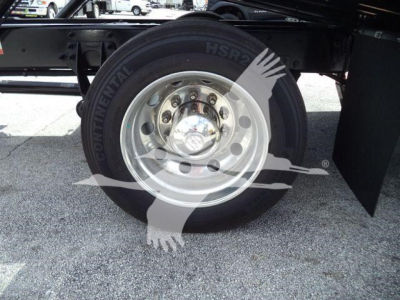 Wheel and tire of a heavy-duty truck showing a steel rim and Continental tire with visible lug nuts and hub area; undercarriage components also visible.