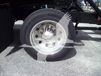 Wheel and tire close-up on a new 2027 International MV rollback truck showing steel wheel, lug nuts, and tire with visible branding.