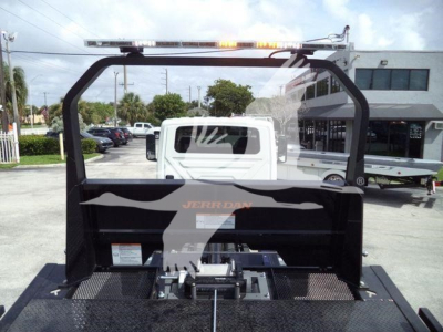 Roll-back truck bed with Jerr-Dan branding and mounting platform, viewed from rear with cab and pickup in background.