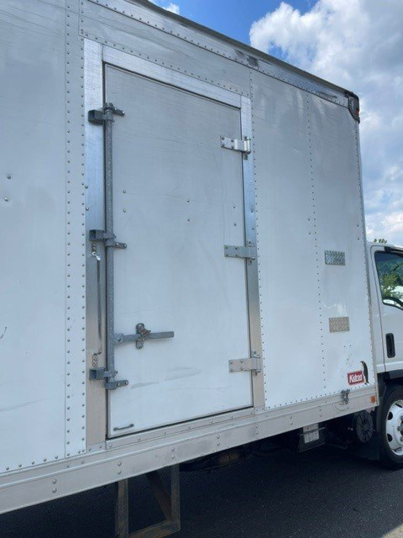 Isuzu NQR box truck rear side door and cargo area with metal hinges and latches visible