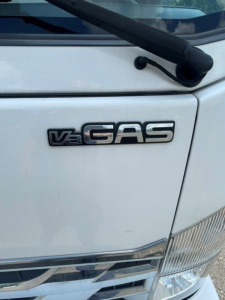 Isuzu NQR truck front door with V3 GAS badge and windshield wiper visible.