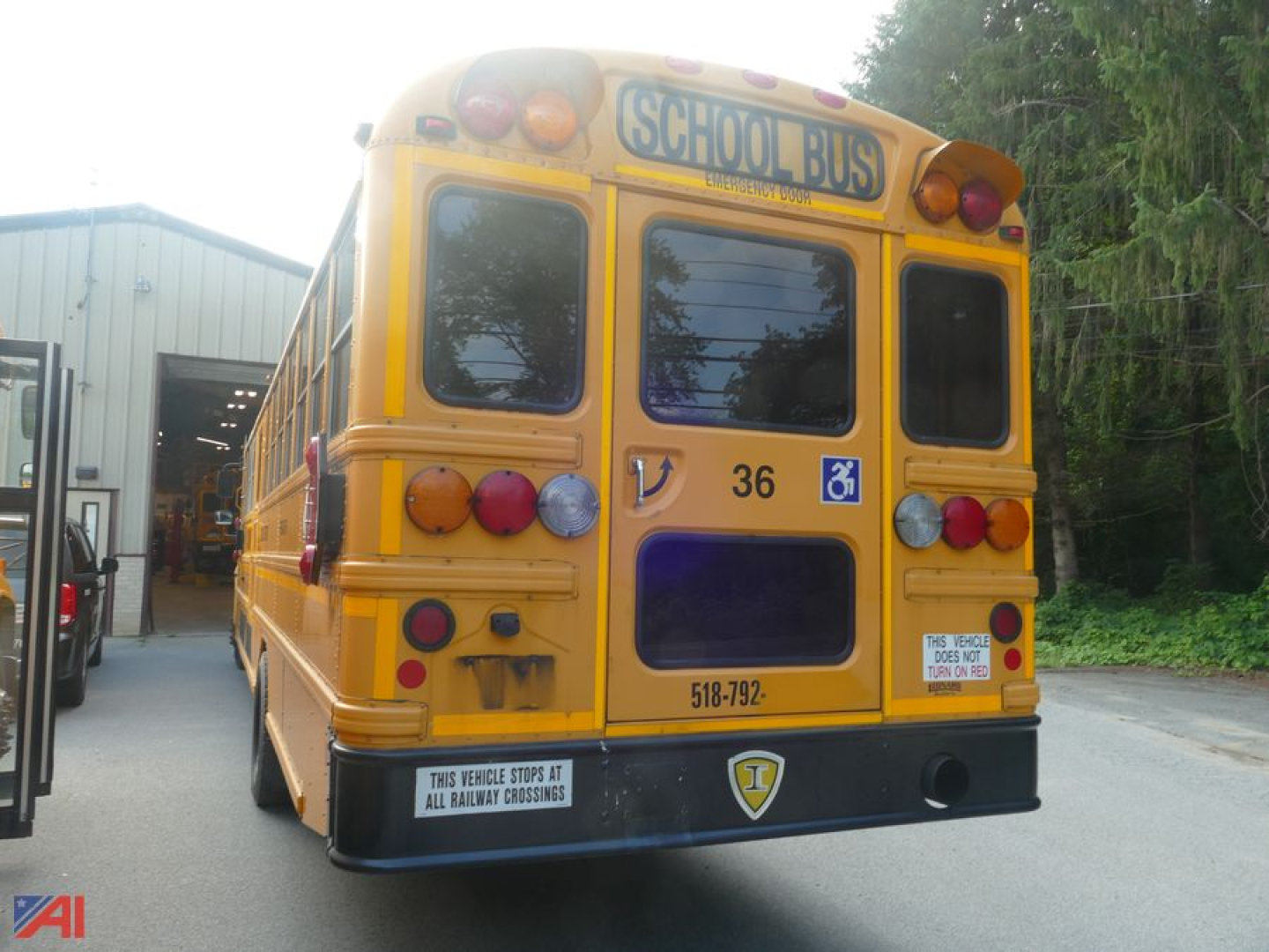 IC Corporation CE series school bus with wheelchair lift rear view showing yellow body, bus number 36, wheelchair symbol, and rear lights.