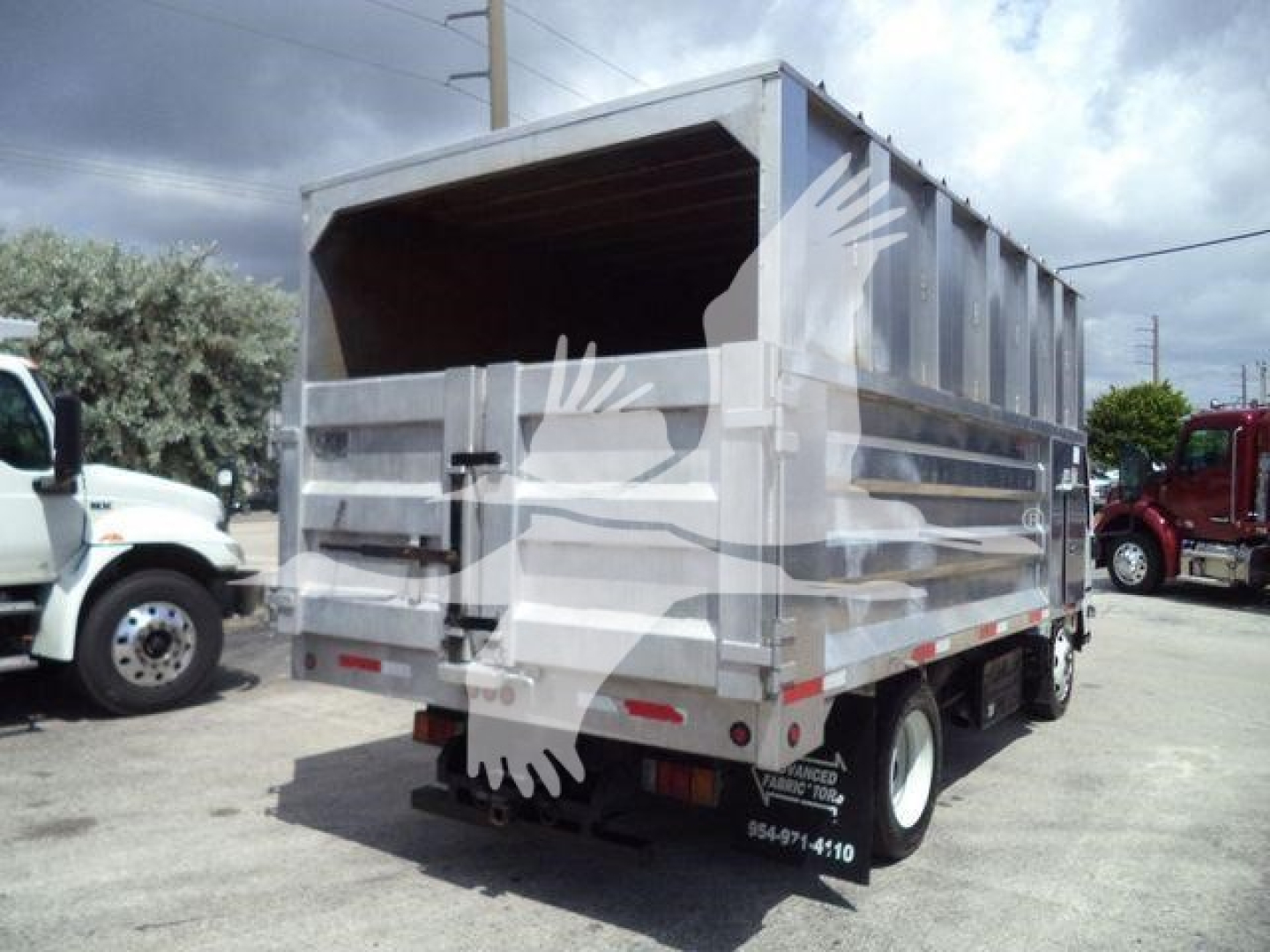 Isuzu NPR XD dump bed truck back view showing dump bed and rear doors with safety latches.