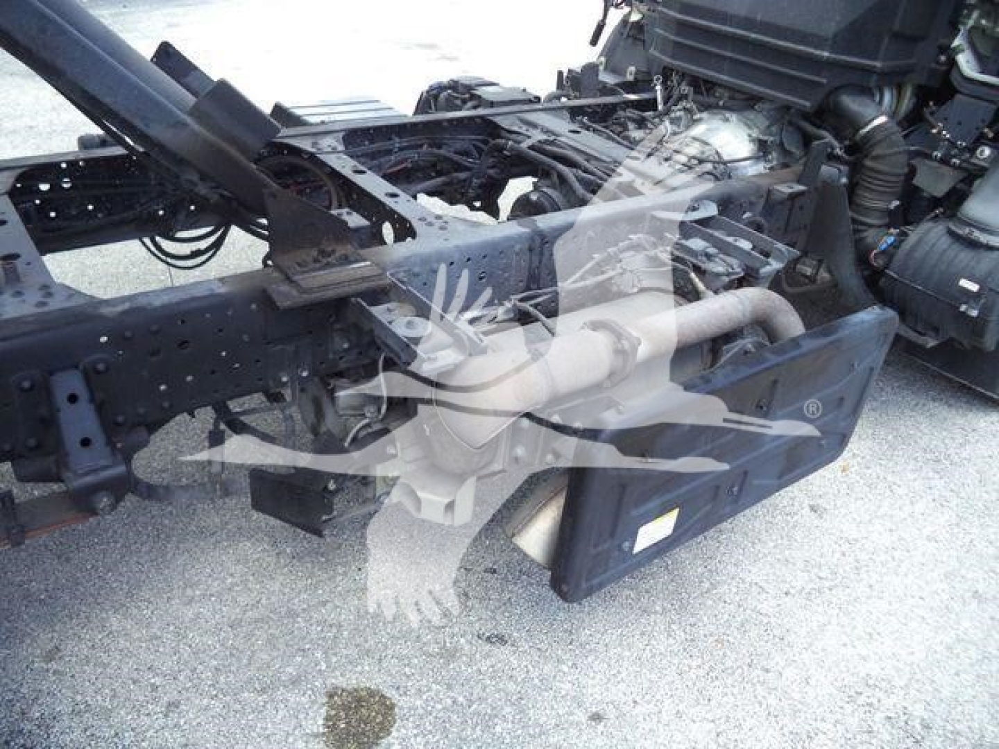 Isuzu NPR Xd chassis showing engine bay area and fuel/electrical lines with chassis frame and underbody components visible.