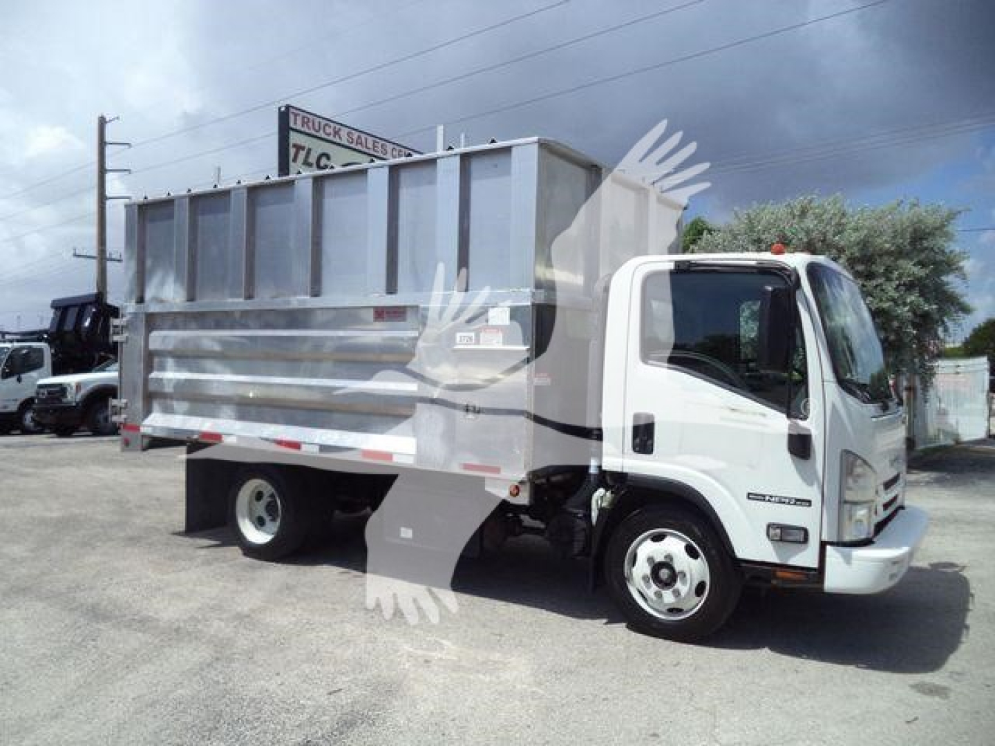 Isuzu NPR XD dump truck side view showing dump bed and cab in a used condition.