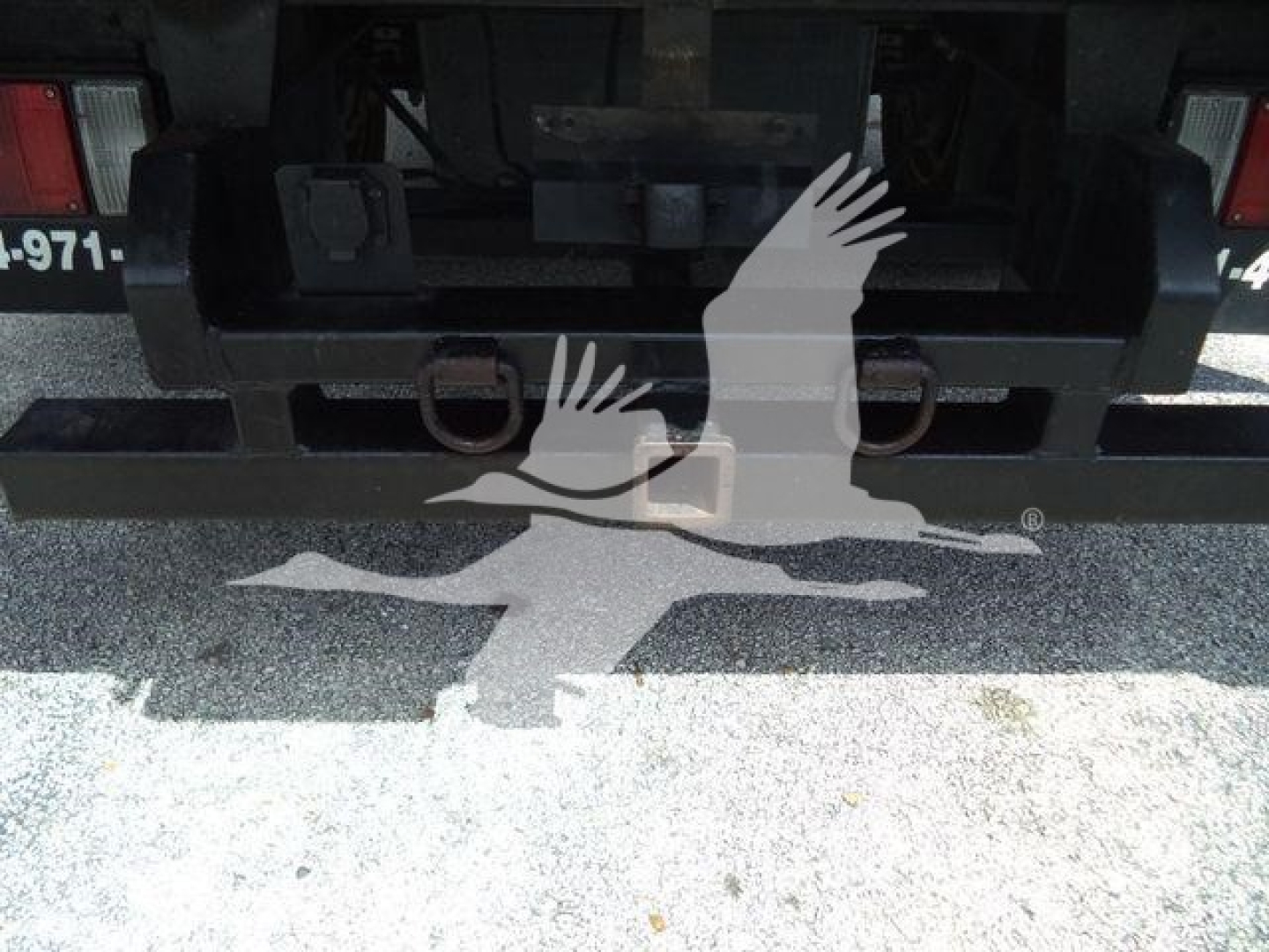 Rear view of Isuzu NPR XD chassis showing hitch and bumper with some identification numbers imparted.