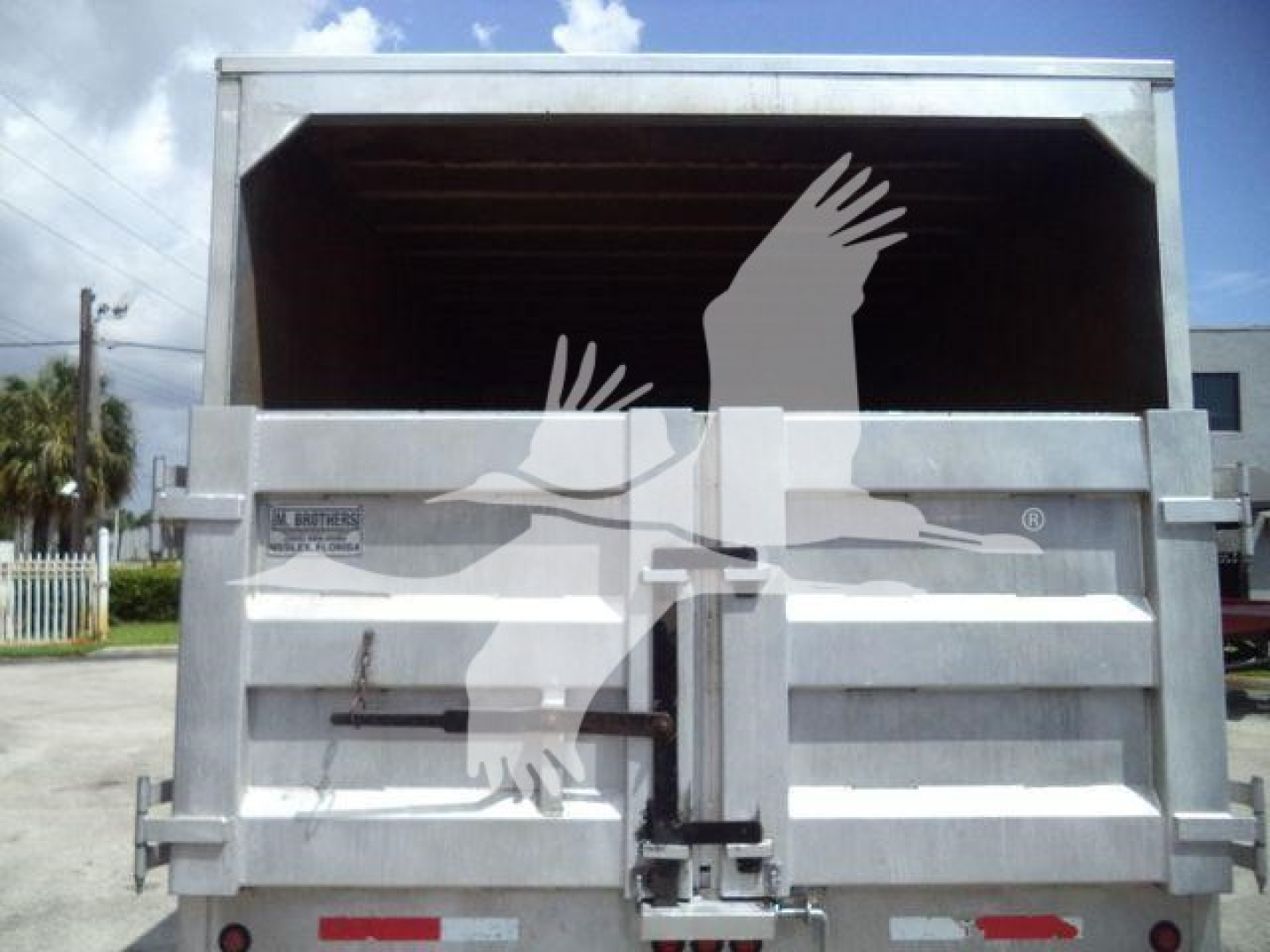 Isuzu NPR XD truck bed with side gates and rear tailgate, metal construction, open cargo area visible.
