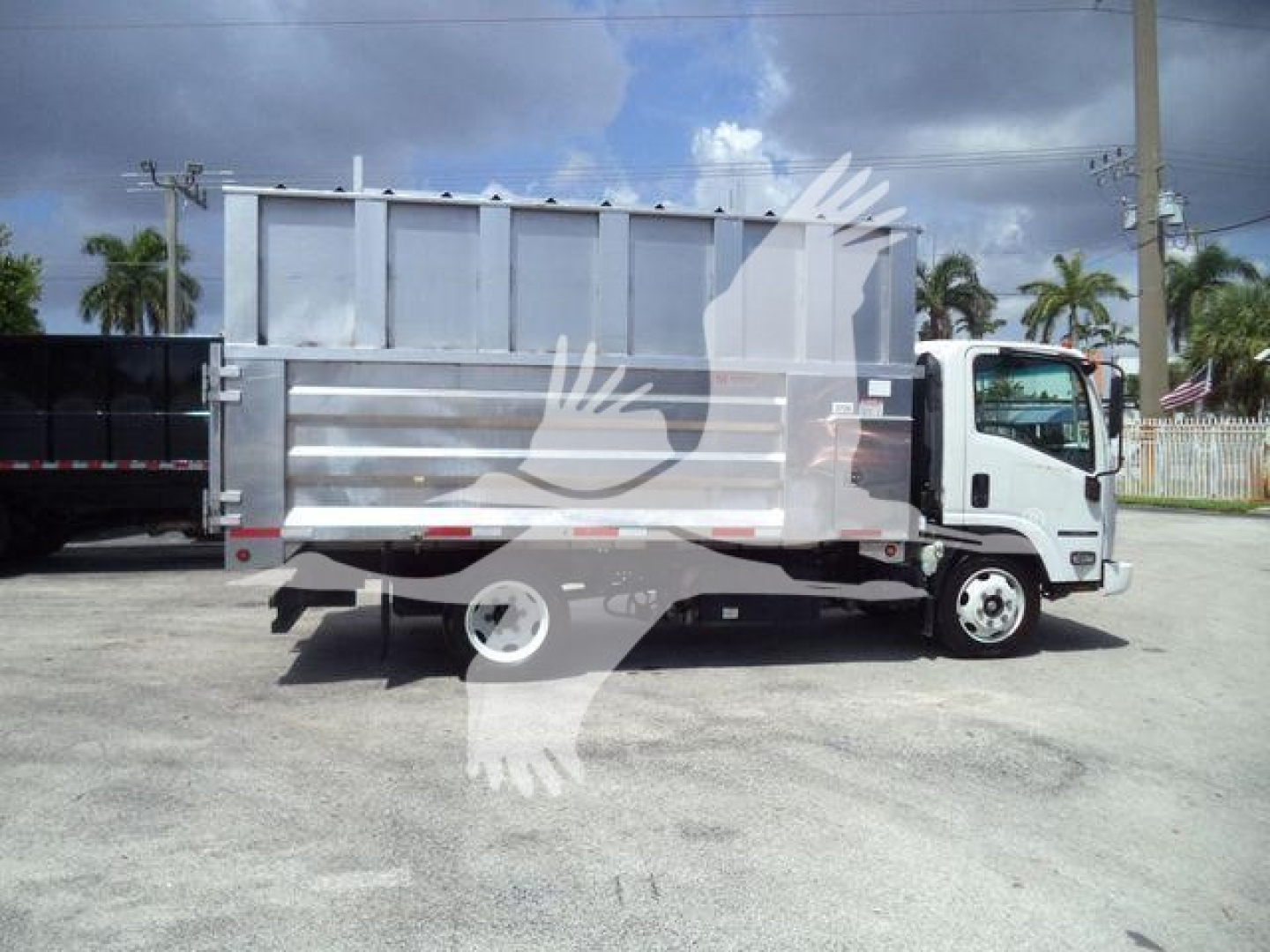 Isuzu NPR XD dump truck side view showing metal dump bed and cab; no legible labels visible due to watermark; general truck body visible
