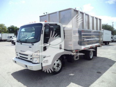Isuzu NPR Xd dump truck in duty cycle with large metal dump body, white cab, side view showing front grill and wheel.