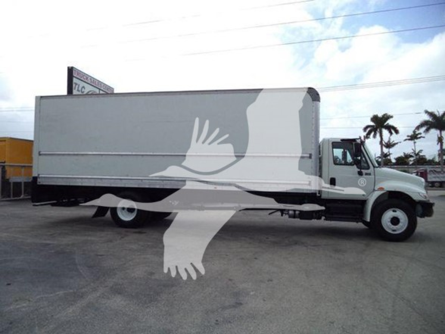 Truck side view showing 2019 International Durastar 4300 box truck with stock number T14761 and VIN 1HTMMMML7KH514761 in a lot.