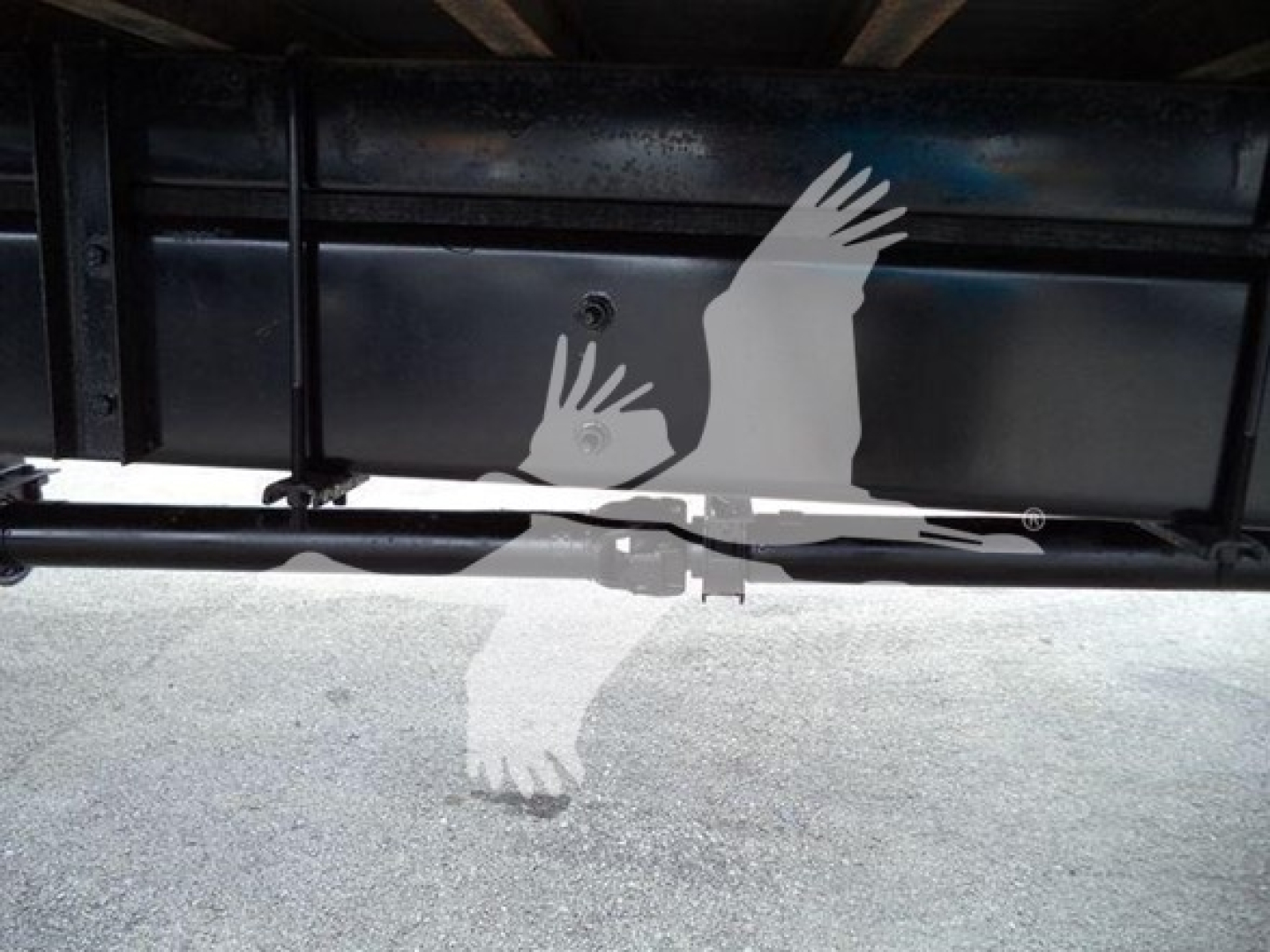 Truck undercarriage showing metal frame and hitch area with a silhouette watermark overlaid