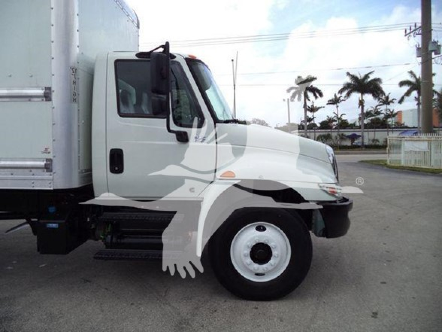 International Durastar 4300 box truck side view showing cab and front wheel. Visible text on sticker area near door and chrome bumper not legible.