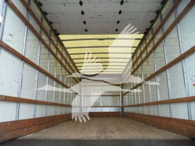 Interior of a box truck cargo area with wooden side rails and empty floor, seen from rear doors.
