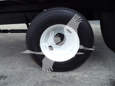 Truck wheel and tire assembly under a box truck showing white steel wheel with black tire; undercarriage silhouette watermark present.