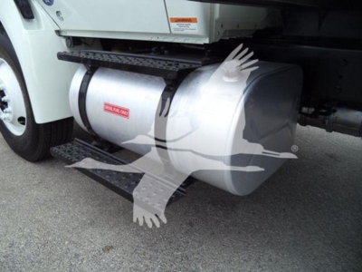 Fuel tank under International Durastar 4300 truck showing large aluminum cylindrical tank and side step, with warning labels visible.