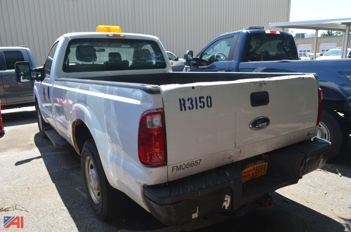 Ford F-250 Super Duty rear view showing tailgate with Ford emblem, pickup bed, and faded numbers R3150 FM0667 on tailgate.