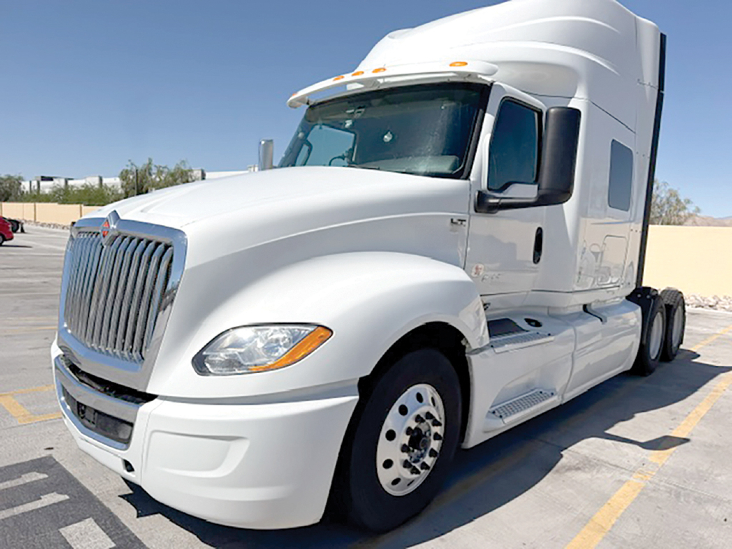 White 2020 International LT625 conventional sleeper truck front-left view showing cab, grille, and front wheel.