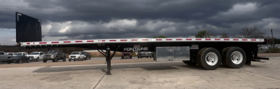 Flatbed trailer with Fontaine 37' combo deck and forklift lift kit, dual rear axles, side rails, and support crank leg visible in truck yard.