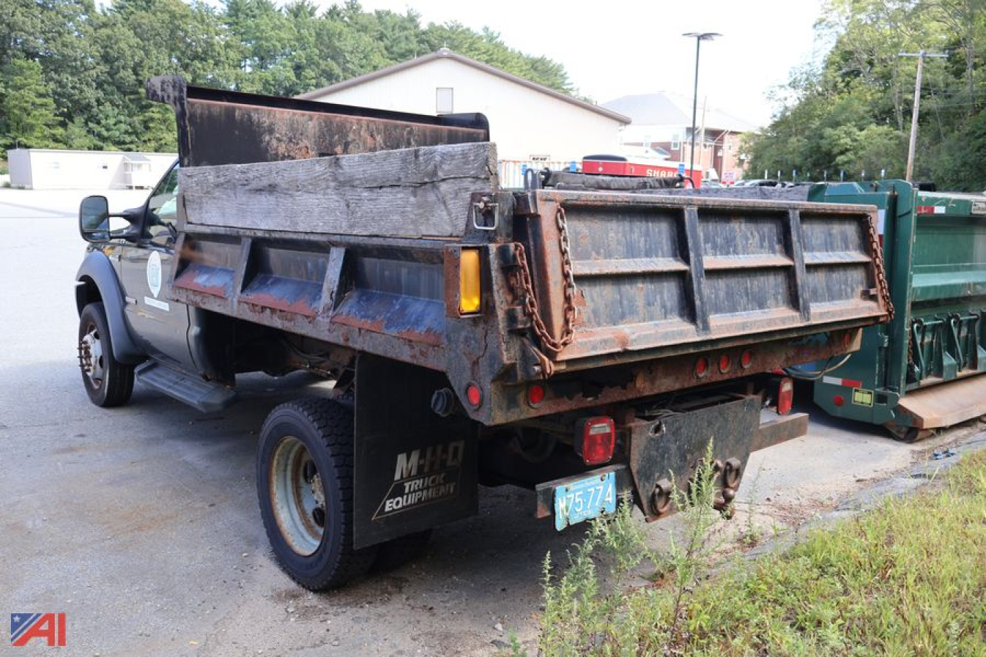 Dump truck bed and rear of a 2006 Ford F-550 dump truck showing rusted bed, taillights, and rear bumper with plastic license plate.