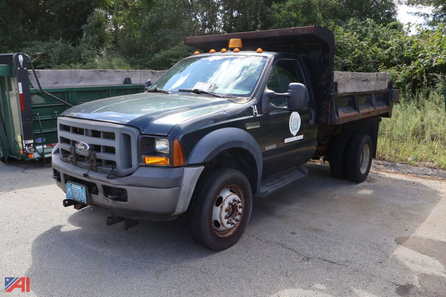 Ford F-550 dump truck in service showing front grille, hood, and dump bed with orange clearance lights on cab roof.